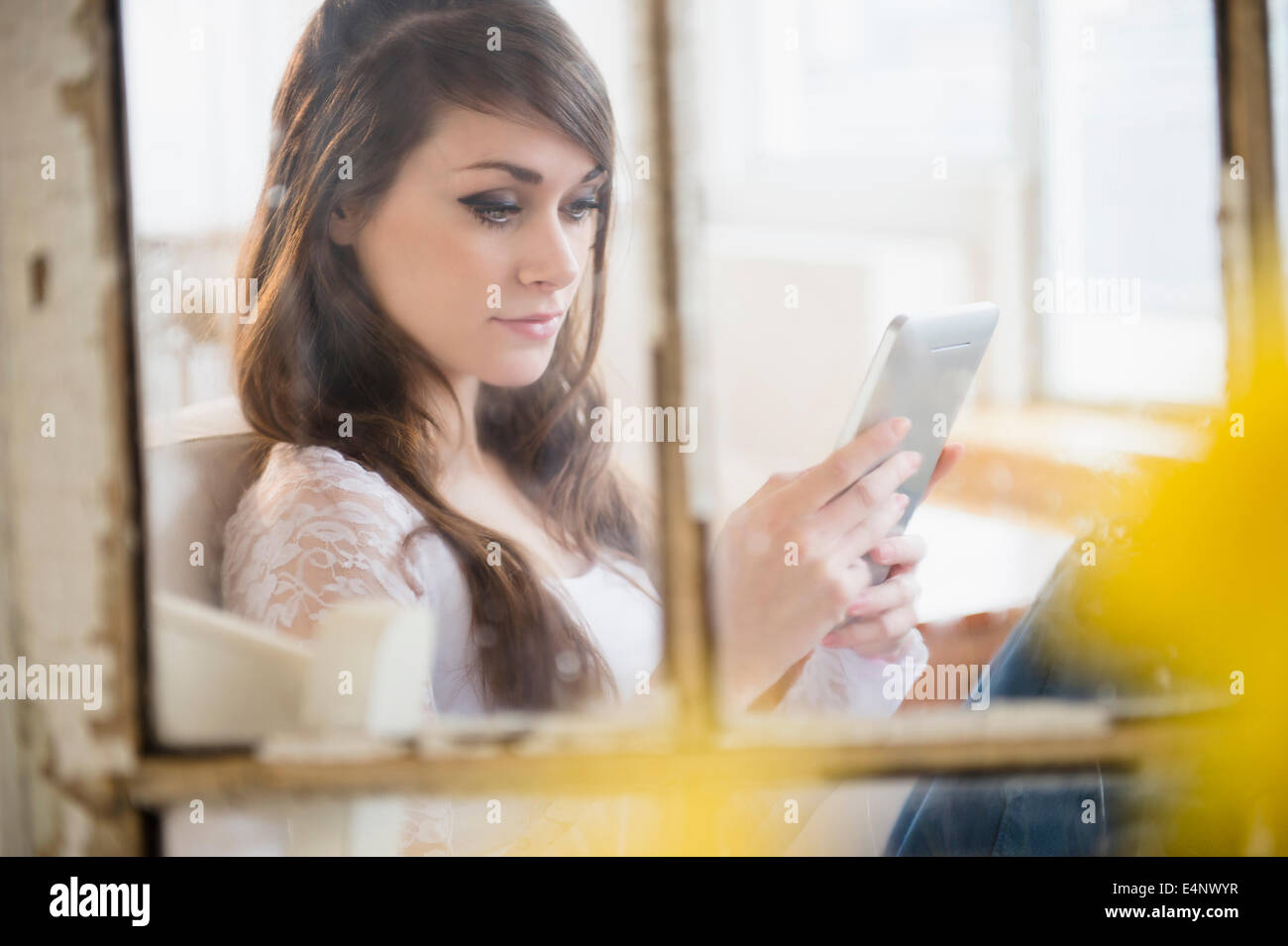 Giovane donna con tavoletta digitale in salotto Foto Stock