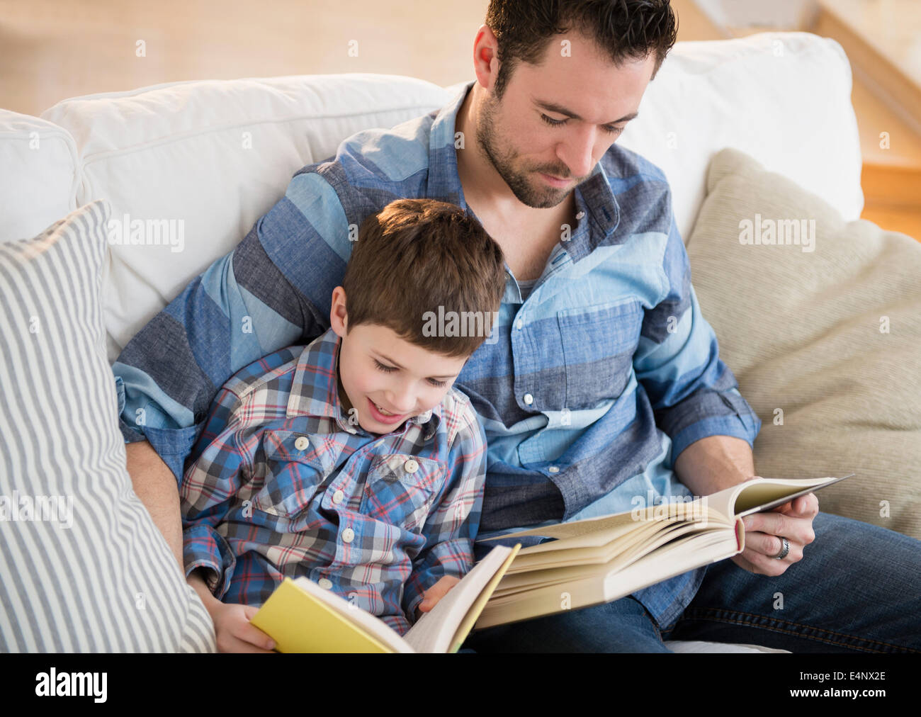 Padre la lettura di libri con suo figlio (8-9) Foto Stock