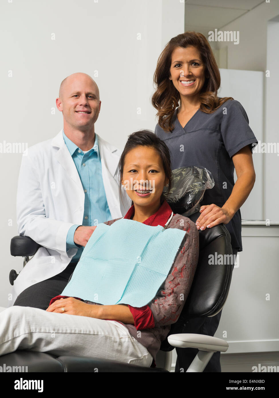 Ritratto di dentista con paziente e assistente Foto Stock