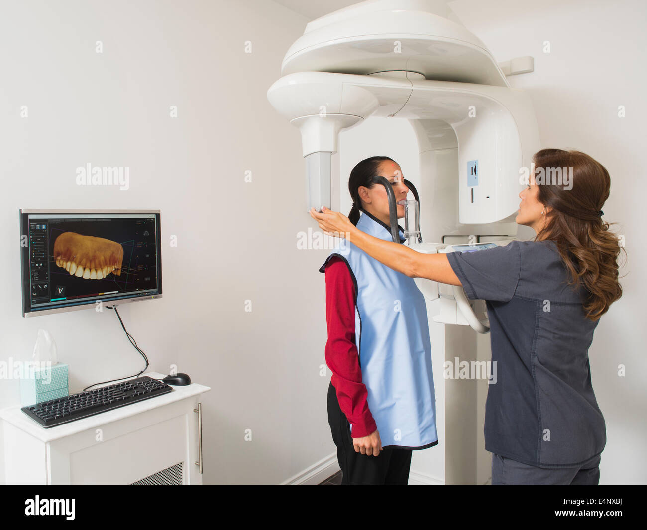 Assistant rendendo immagine a raggi x dei denti del paziente Foto Stock