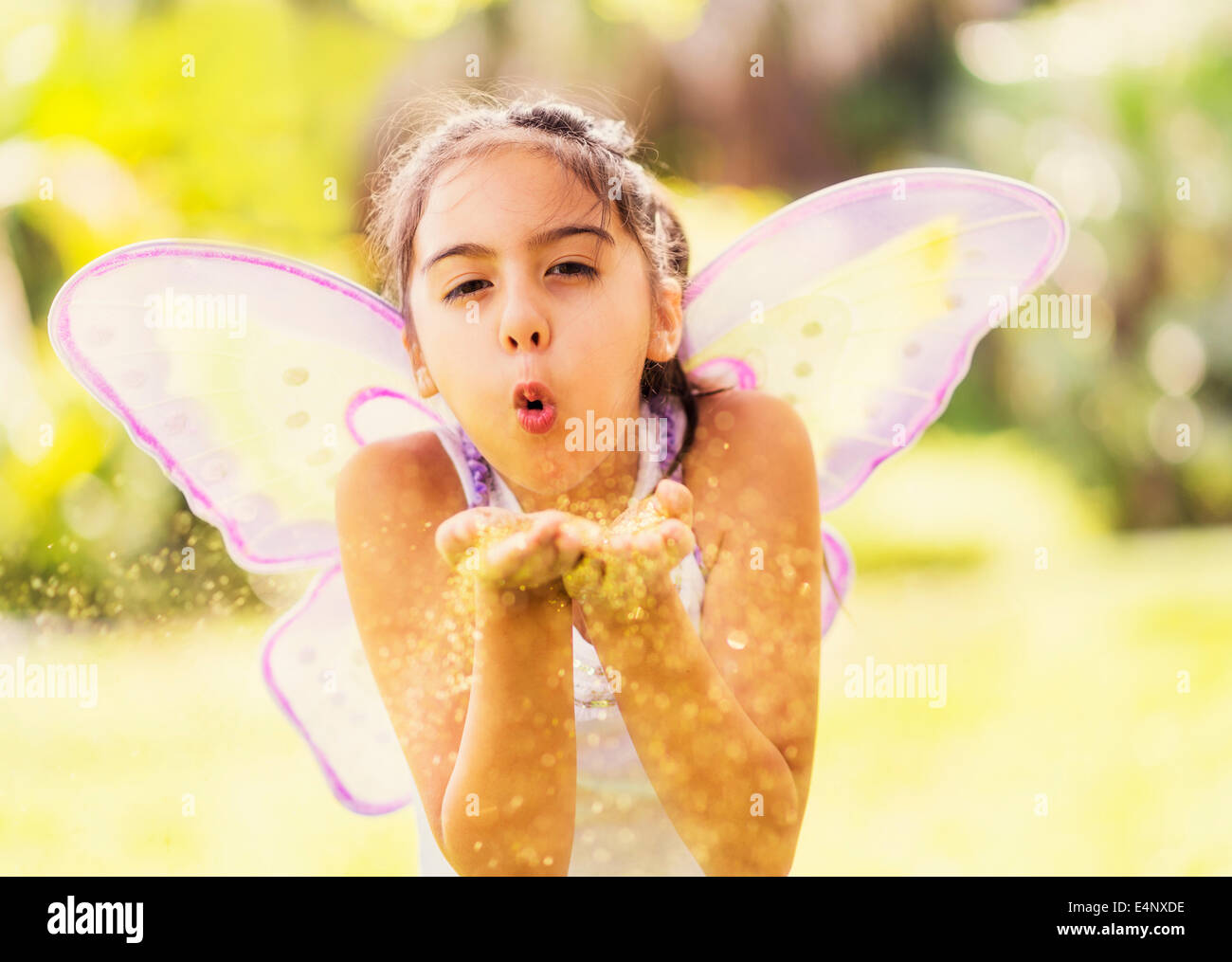 La ragazza (8-9) soffiaggio polvere di fata Foto Stock