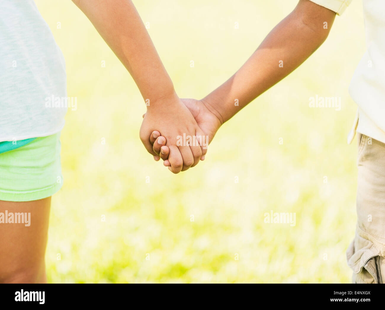La ragazza (8-9) e ragazzo (6-7) tenendo le mani, close up Foto Stock