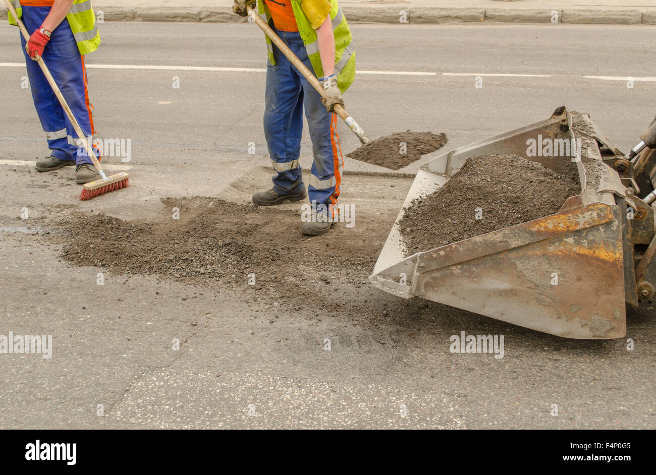 Lavoratore di asfalto di funzionamento durante la costruzione di strade e lavori di riparazione Foto Stock