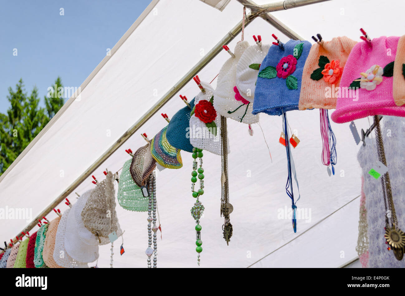 Colorate sottili baby cappelli di molla appendere su corda fiera del villaggio Foto Stock