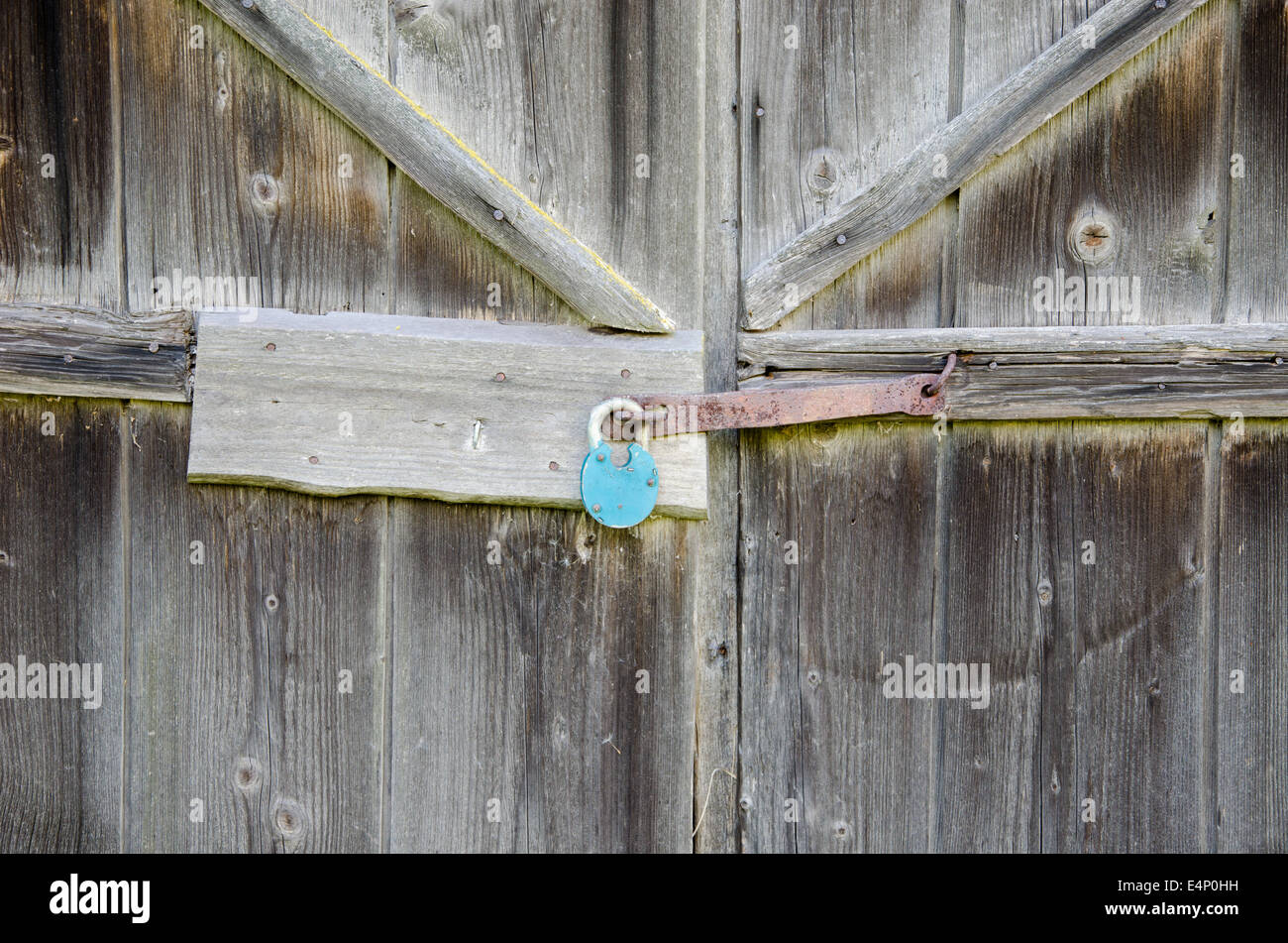 Rurali fienile in legno porta con blu ferro appeso di bloccaggio Foto Stock