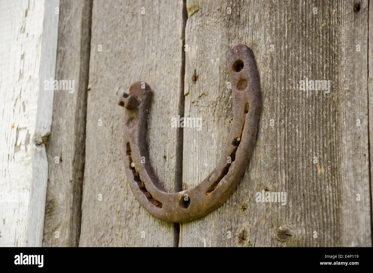 Ferro vecchio arrugginito ferro di cavallo simbolo della felicità su sfondo di legno Foto Stock