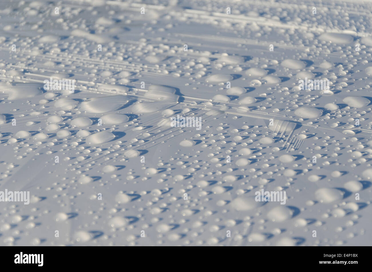 Pioggia di gocce di acqua glisten bianco sulla superficie di materiale di sfondo. Foto Stock