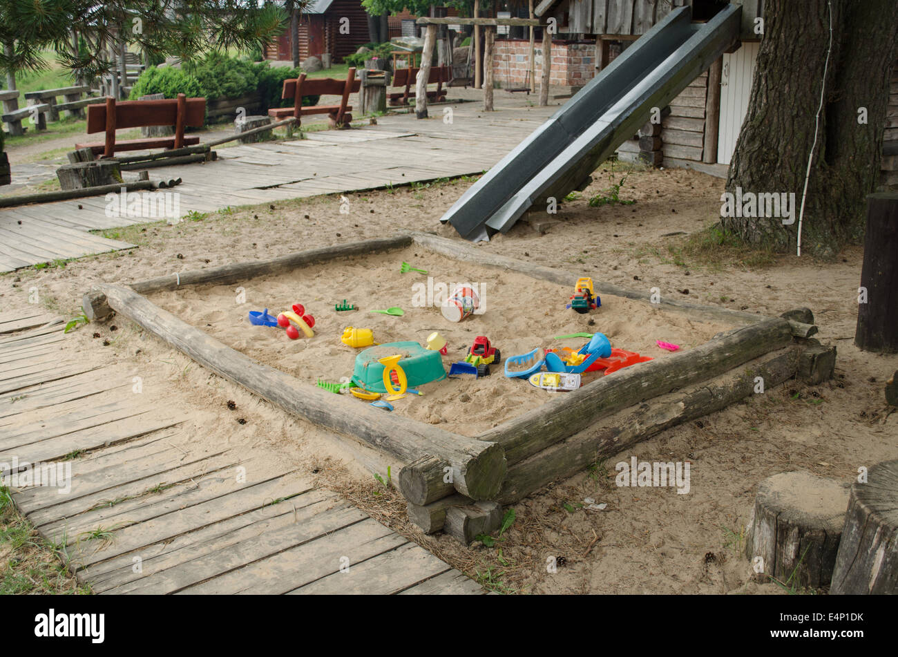 Parco giochi sandbox piena di giocattoli sparsi sul parco dei bambini nel periodo estivo Foto Stock