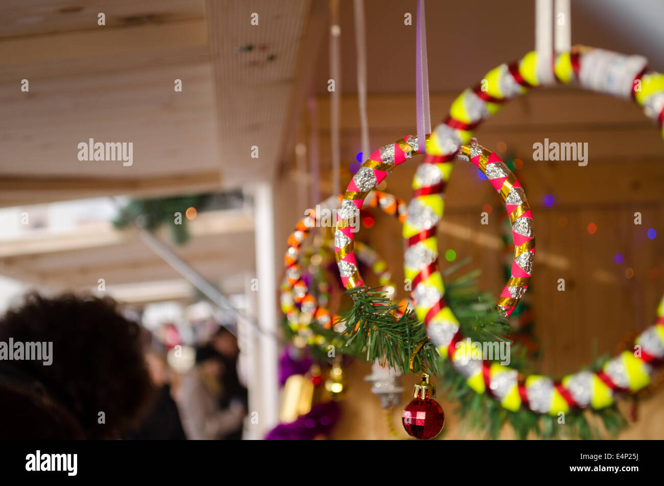 Decorazioni festive anelli rotanti nastro lucido con vetro rosso toy appeso alla vetrina di Natale Foto Stock