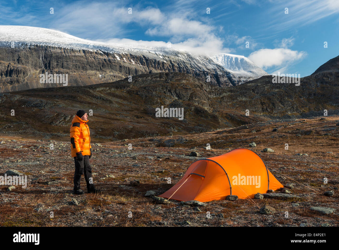 Mann neben Zelt mit Blick auf den Berg Sinnitjohkka, Kebnekaisefjaell, Norrbotten, Lappland, Schweden Foto Stock