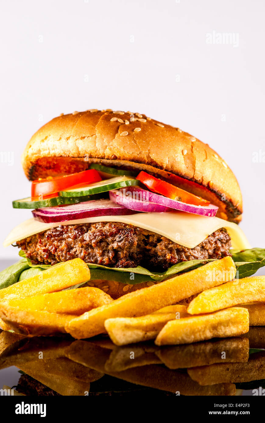 Hamburger freschi con verdure e patate fritte a riflettere sullo sfondo Foto Stock