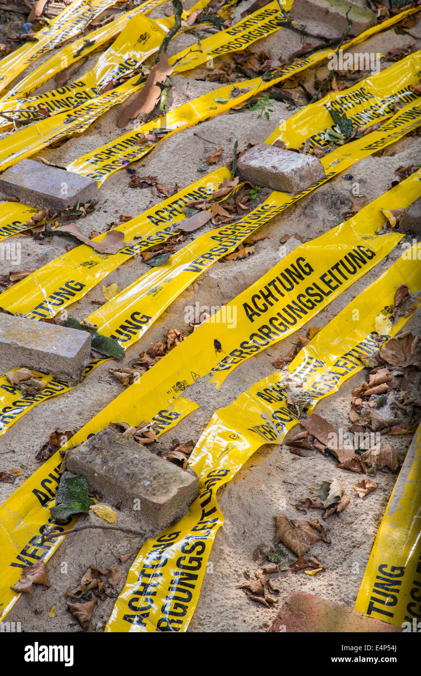 Sito in costruzione, giallo bande plastiche mostrano le linee di alimentazione sepolti nella terra Foto Stock