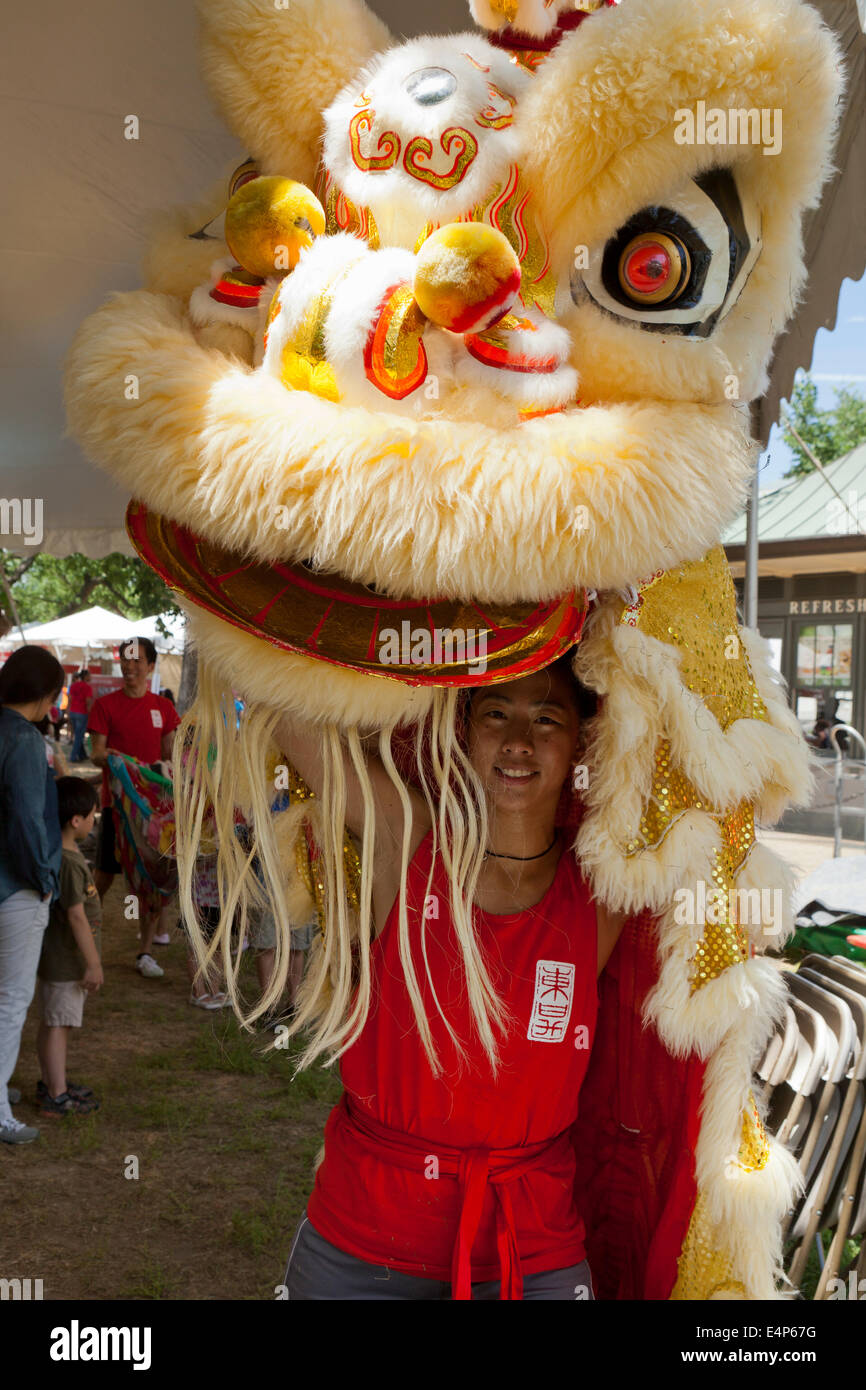 Donna mettendo su Lion costume al cinese festival - USA Foto Stock