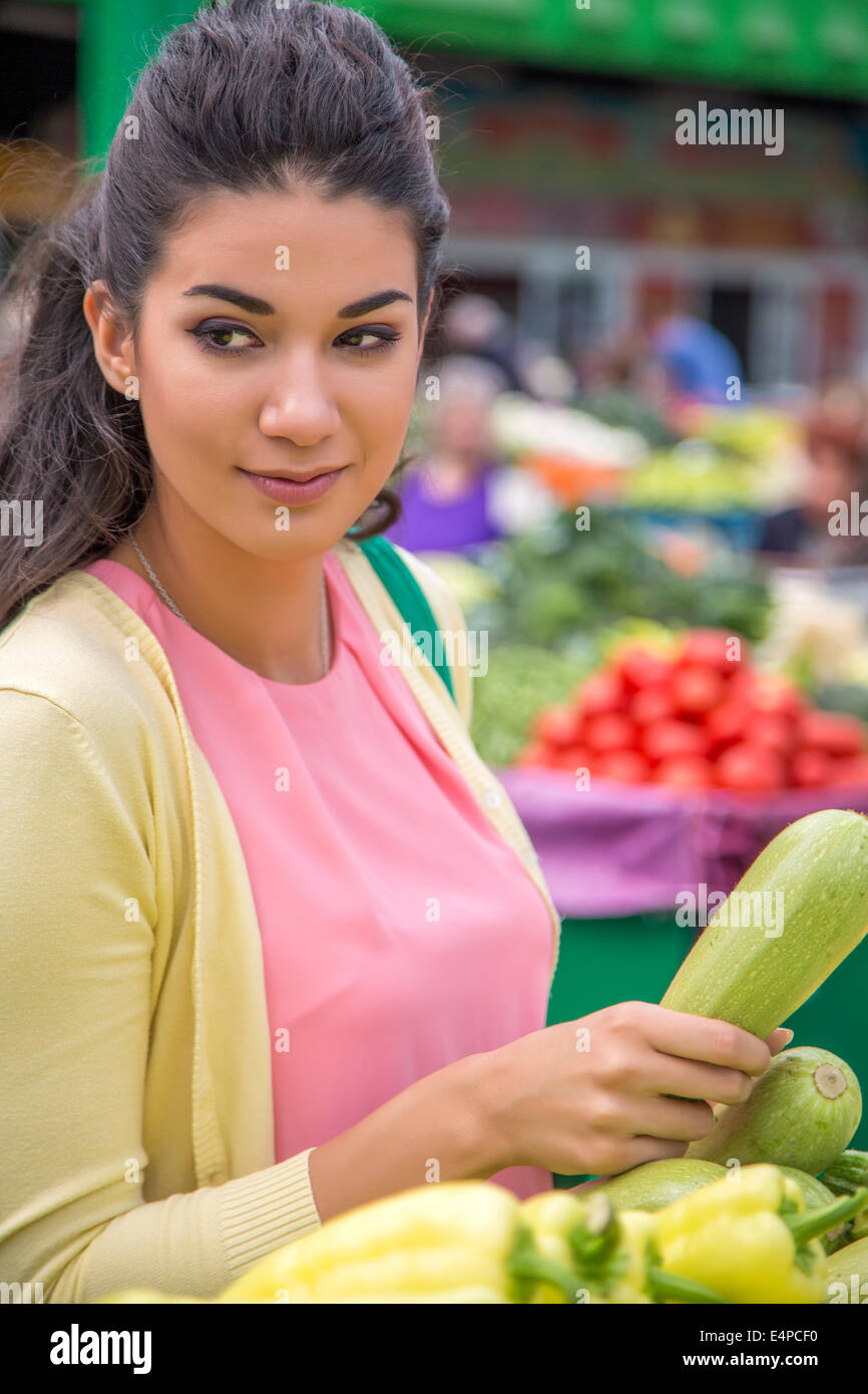 Piuttosto giovane donna acquistare verdure sul mercato Foto Stock
