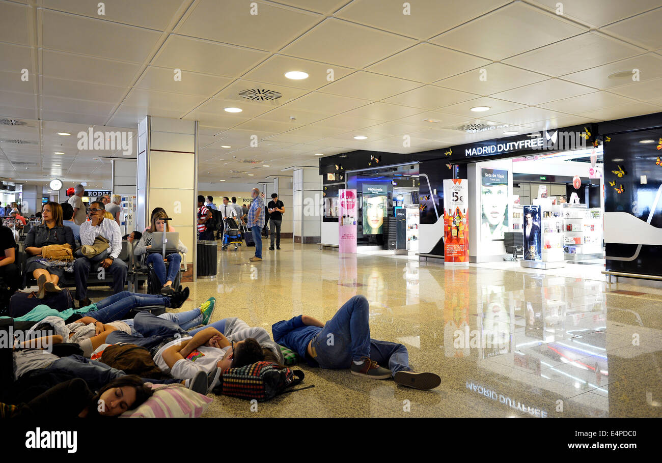 Sovraffollata area di attesa, cancelli, stanchi dei passeggeri, duty-free zone, aeroporto Barajas di Madrid, Madrid, Spagna Foto Stock