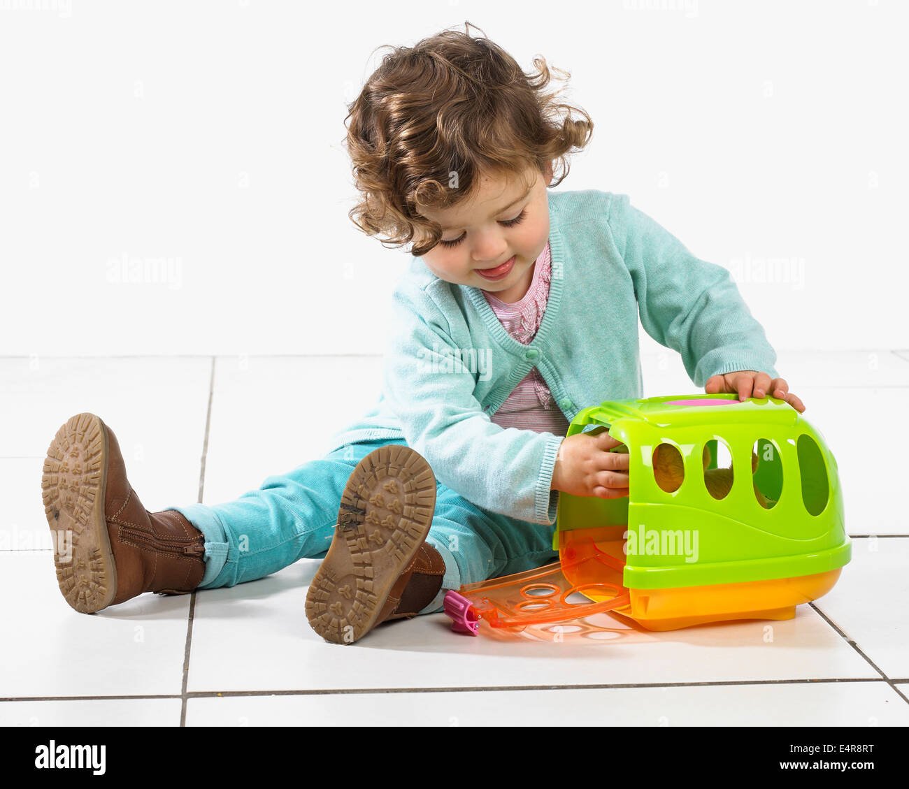 La ragazza (2 anni) con luminoso plastica vettore pet, pet all'interno di coniglio Foto Stock