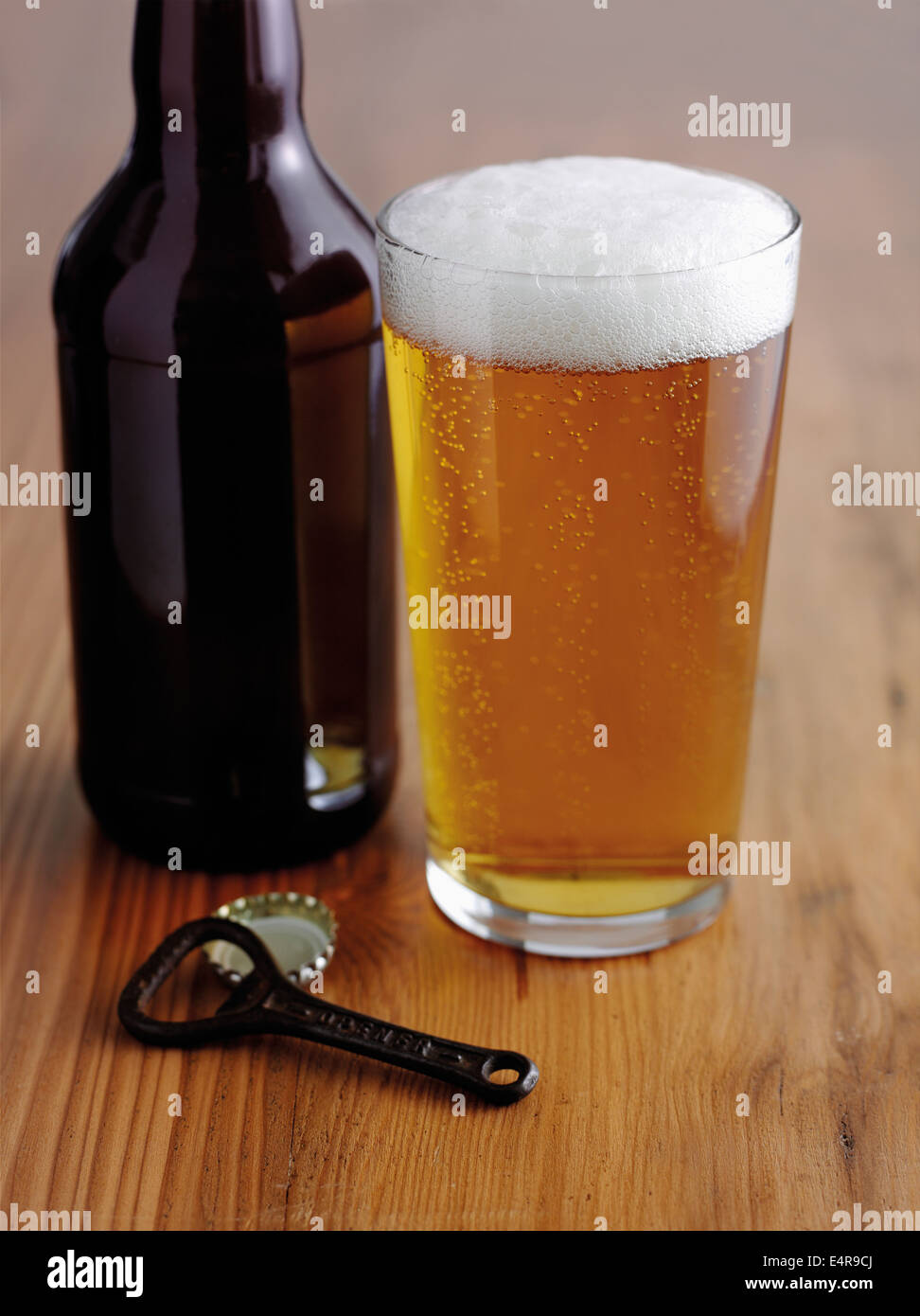 Bicchiere di pale ale seduti fianco a fianco con una bottiglia e apribottiglie Foto Stock