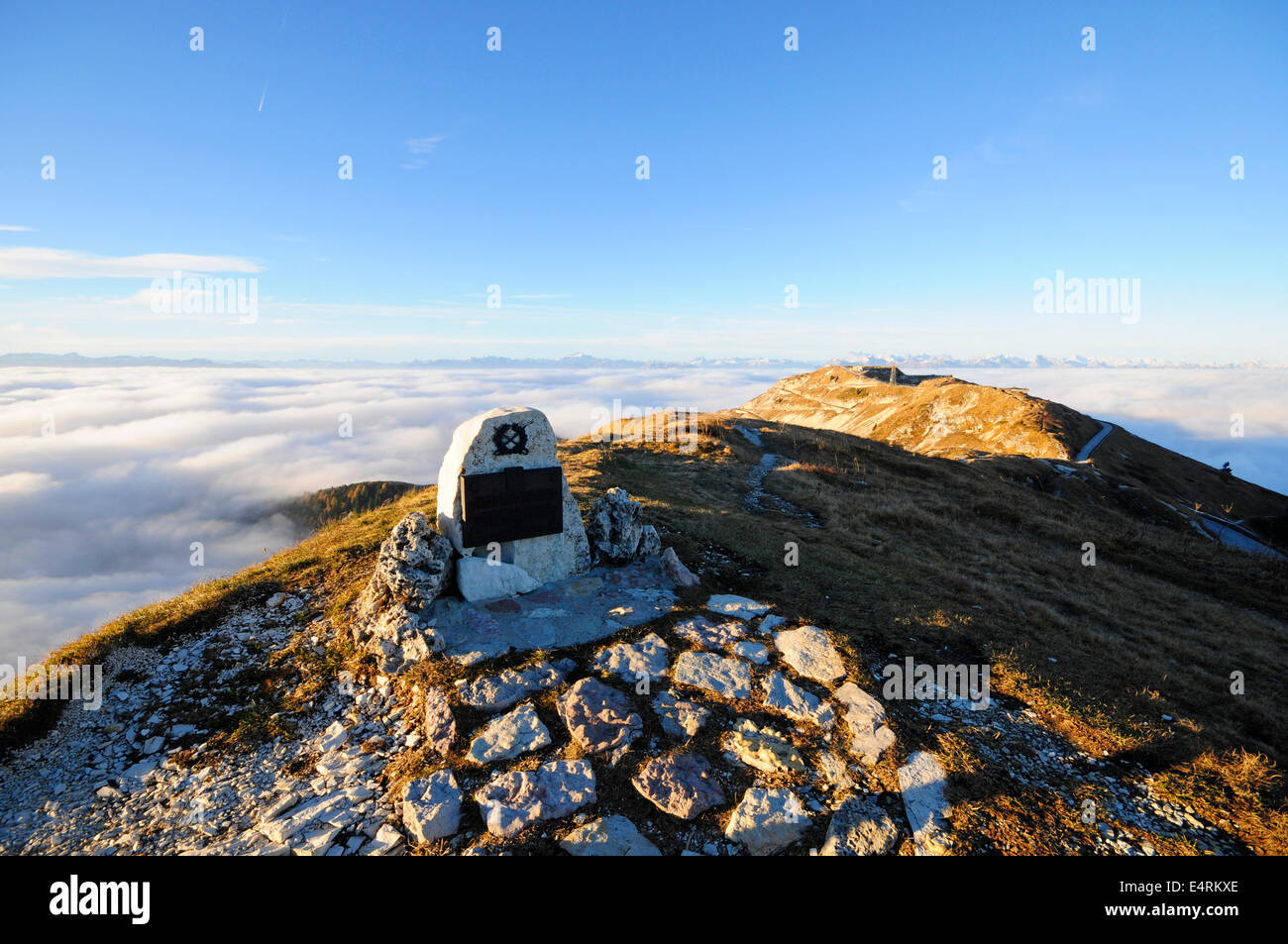 Sacrario militare sulla cima di una montagna con la luce che emerge dalle nuvole Foto Stock