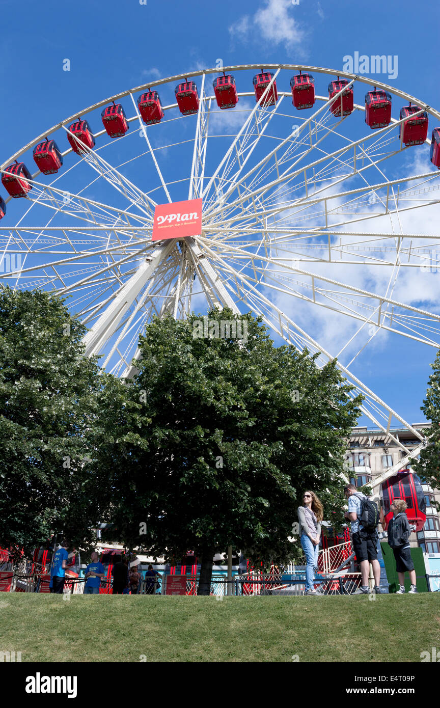 I turisti di fronte al Festival ruota panoramica Ferris in Princes Street Gardens, Edimburgo, Scozia Foto Stock
