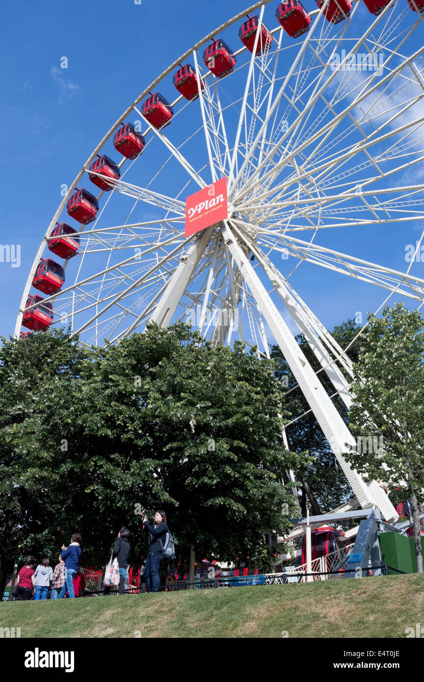 I turisti di fronte al Festival ruota panoramica Ferris in Princes Street Gardens, Edimburgo, Scozia Foto Stock
