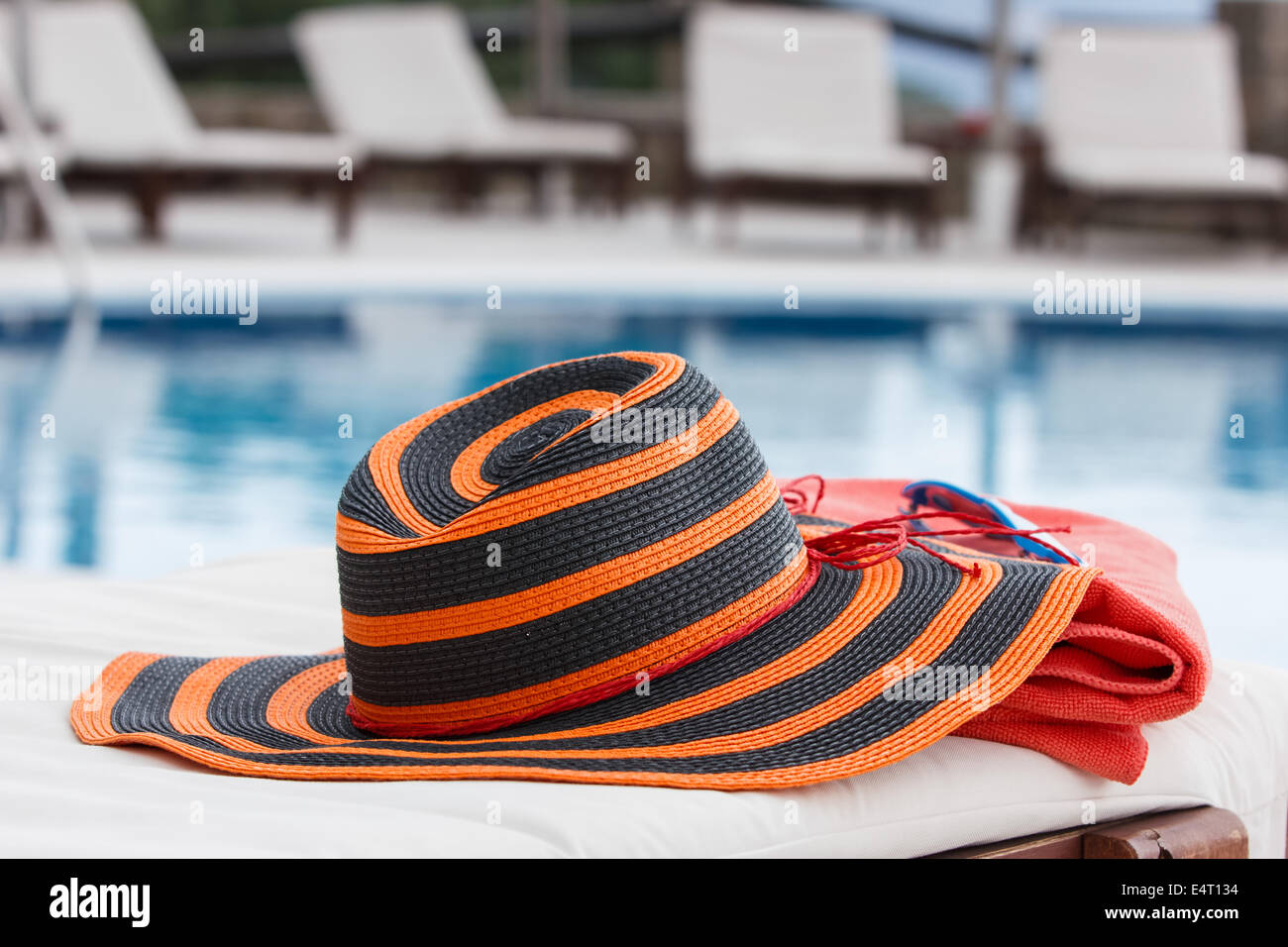Accessori per prendere il sole sul telo da spiaggia da una piscina Foto Stock