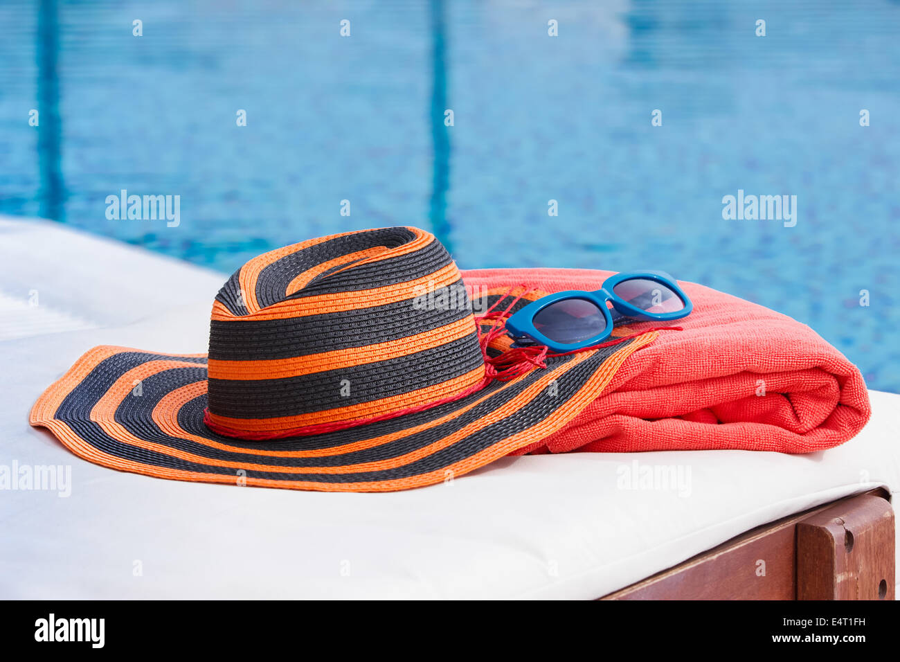 Accessori per prendere il sole sul telo da spiaggia da una piscina Foto Stock