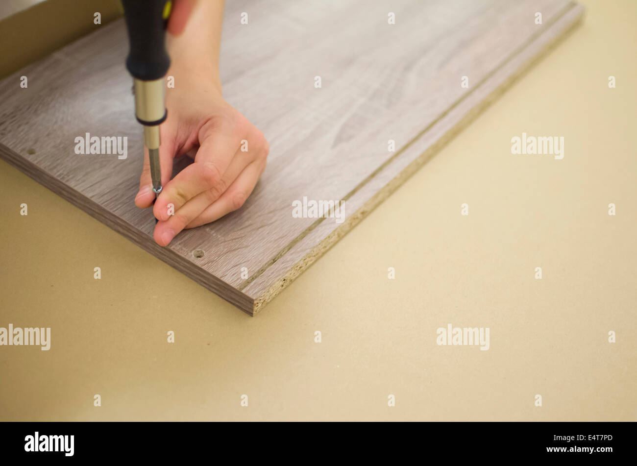 Arredamento grigio imbullonatura con la mano sul pavimento Foto Stock