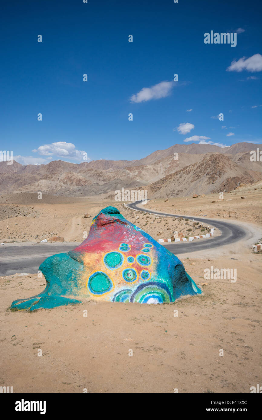 Roccia dipinta psichedelica a forma di rana. Un'inaspettata e divertente caratteristica stradale in Ladakh, India. Foto Stock