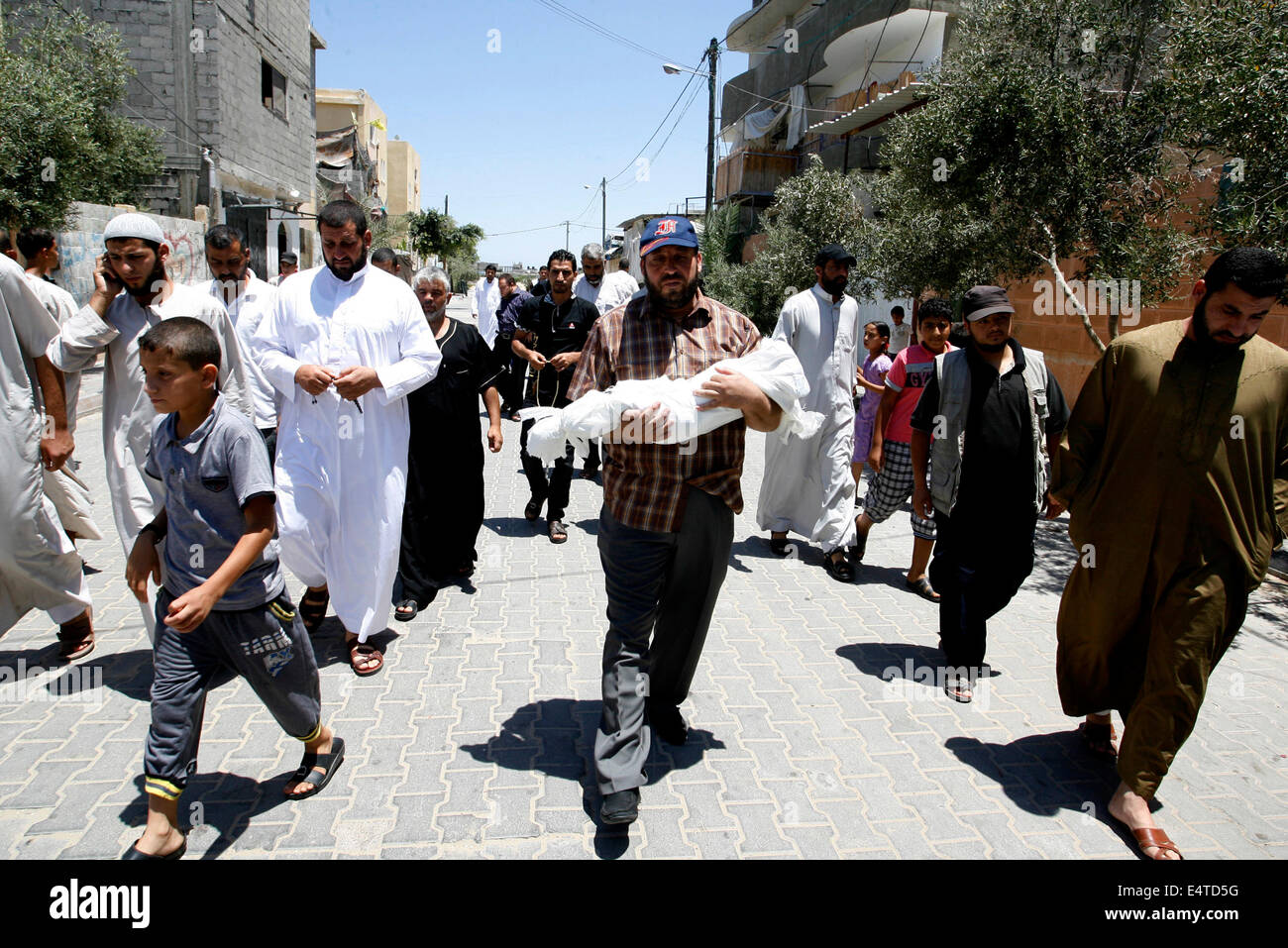 La striscia di Gaza, Territori palestinesi. 16 Luglio, 2014. Uno dei parenti di cinque-mese-vecchio bambino palestinese, Lama al-Satary, porta un corpo durante il suo funerale a Rafah, il sud della striscia di Gaza. A seguito di un militare israeliano sciopero. Israele ha esortato 100.000 Gazans a fuggire dalle loro case il mercoledì, ma la spia è stato largamente ignorato nonostante una intensificazione dei militari di nove giorni di campagna dopo che Hamas snobbato un cessate il fuoco. Credito: Abed Rahim Khatib/Pacific Press/Alamy Live News Foto Stock