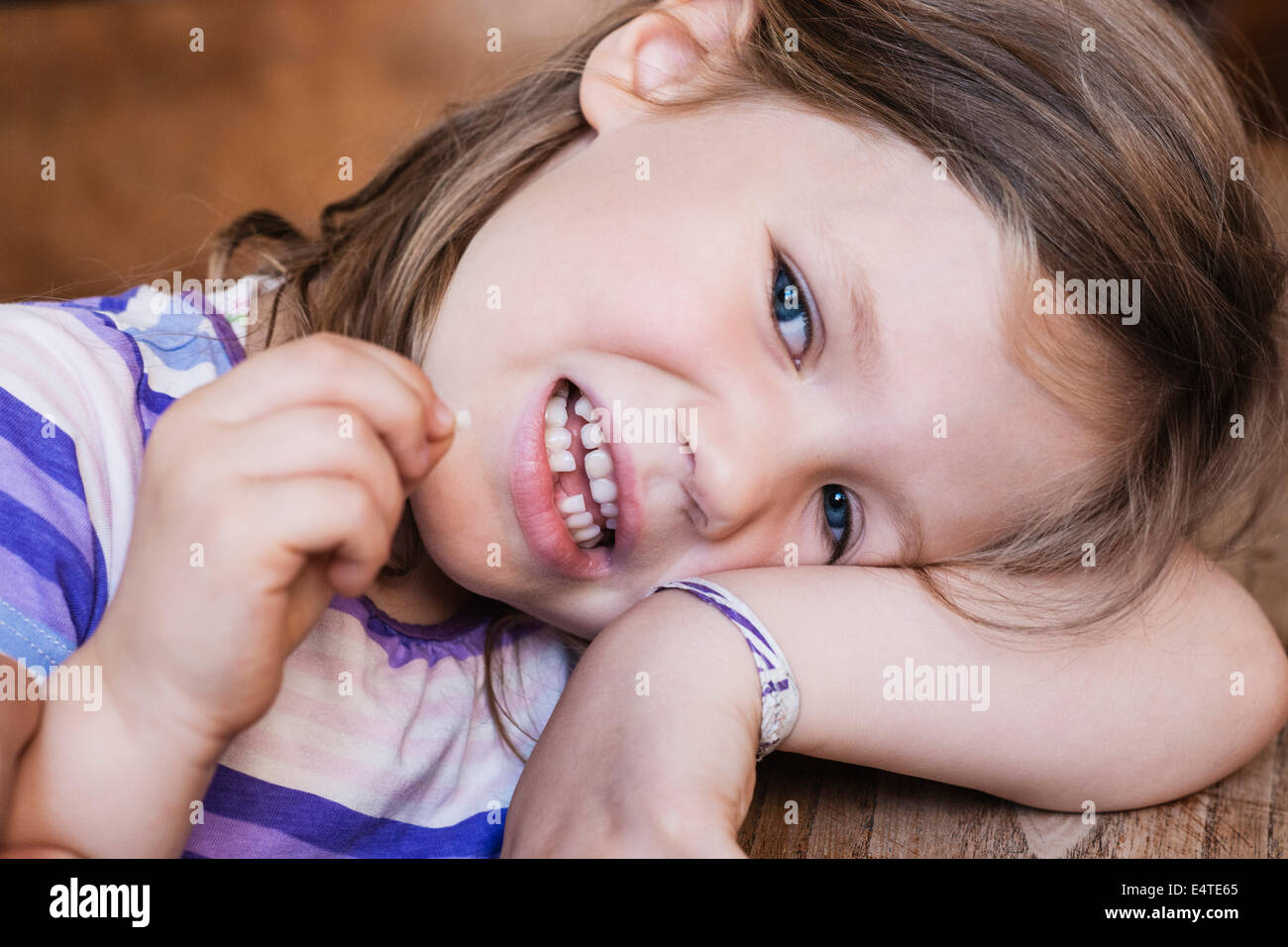 Close-up di una ragazza guardando la fotocamera e tenendo il suo dente estratto Foto Stock