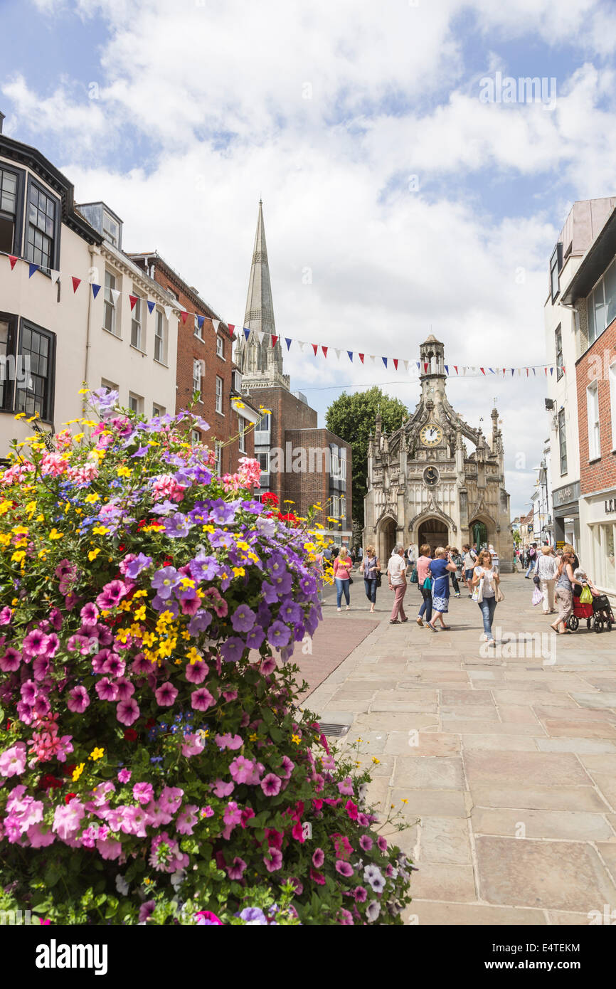 Chichester city centre e Chichester croce su una trafficata soleggiata giornata estiva con display a colori dei fiori, West Sussex, Regno Unito Foto Stock