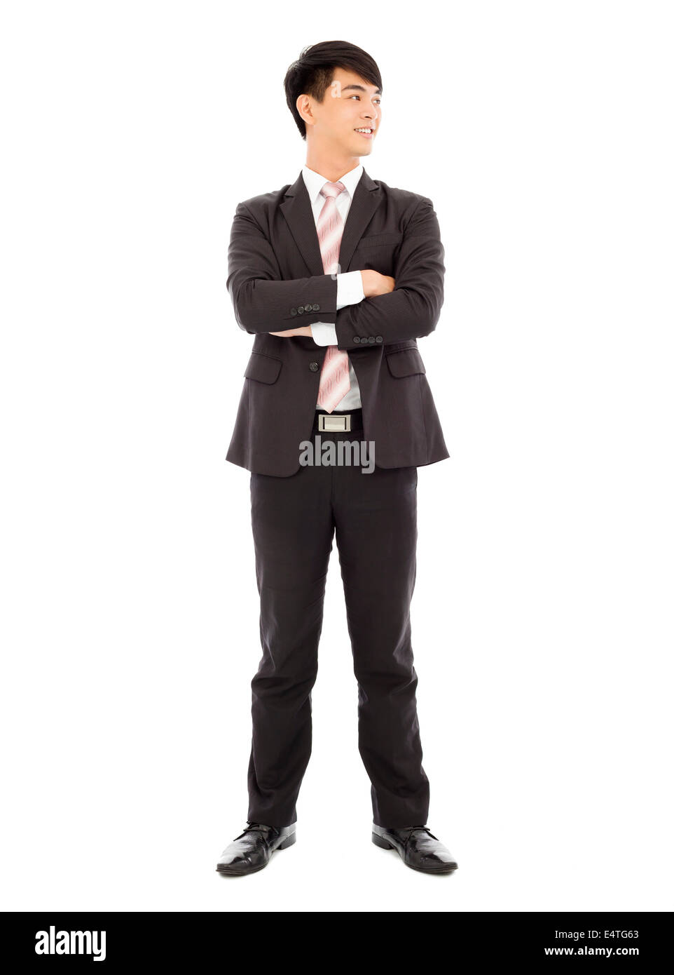Imprenditore sorridente in piedi e bracci incrociati su bianco Foto Stock