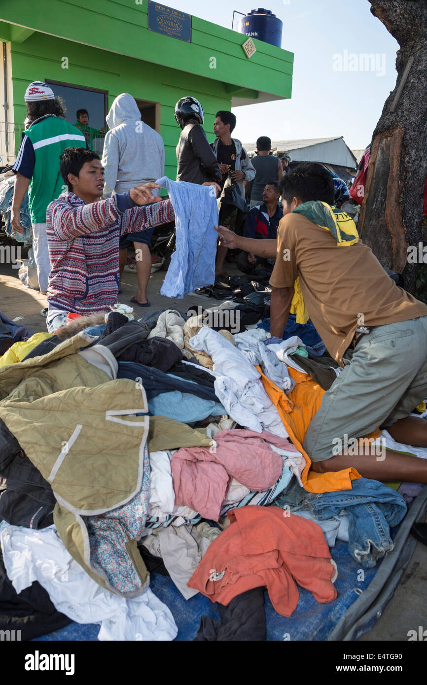 Jimbaran, Bali, Indonesia. Indumenti usati venditore in spiaggia-mercato laterale. Foto Stock