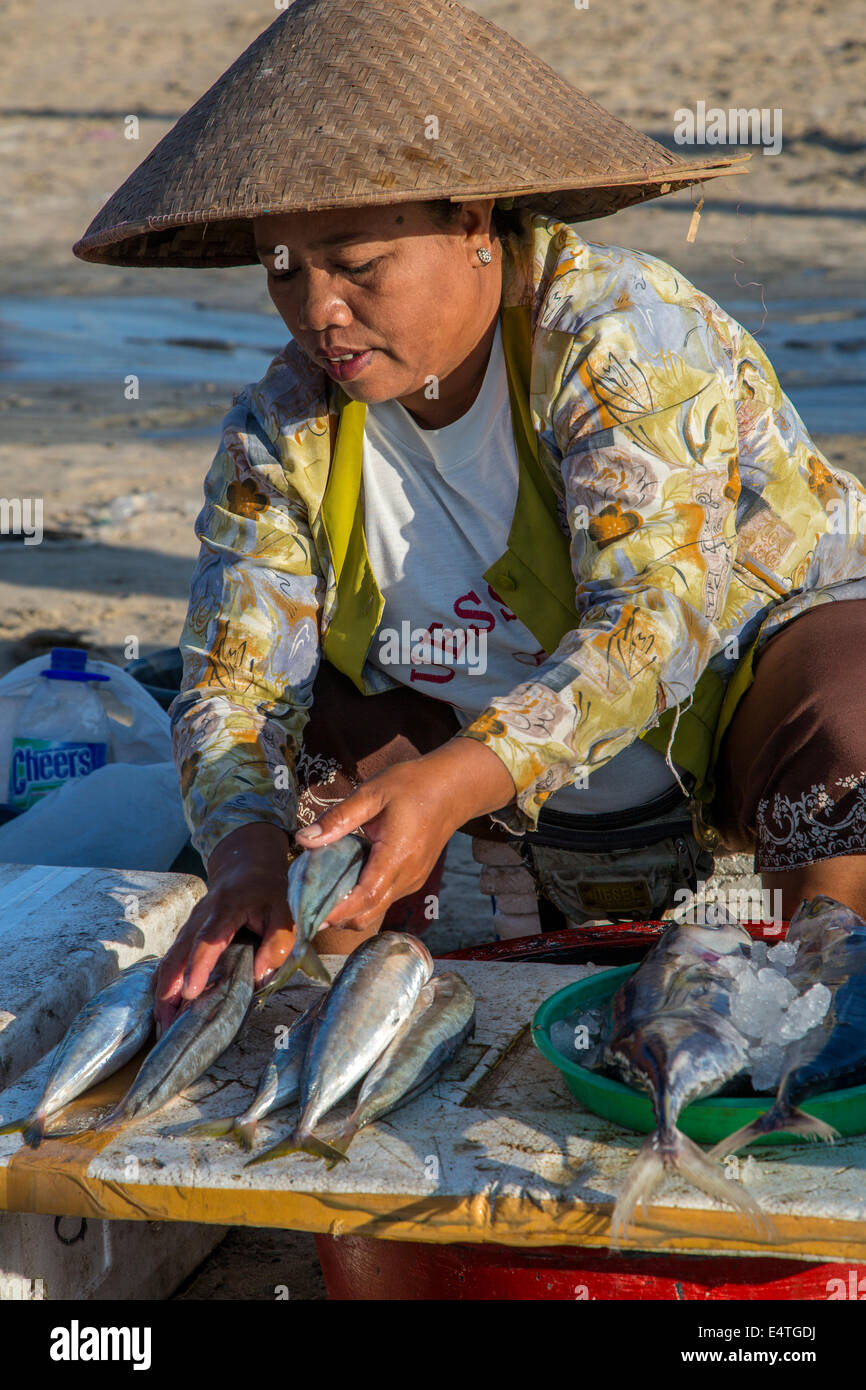 Spiaggia di Jimbaran, Bali, Indonesia. Donna Balinese di vendita del pesce sulla spiaggia di mattina presto. Foto Stock