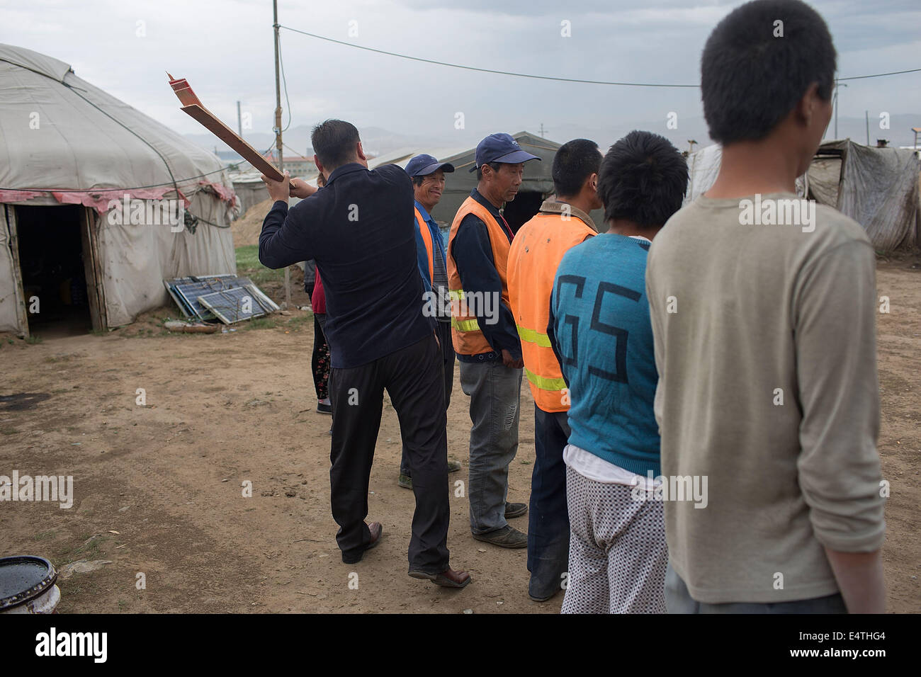 Ulaanbaatar, in Mongolia. Il 27 giugno, 2014. ULAANBAATAR, IN MONGOLIA - 27 giugno: un membro del Bosoo Khukh Mongol colpisce un gruppo di Cinesi dei lavoratori migranti con un pezzo di legno dopo aver ascoltato una relazione che gli immigrati cinesi hanno attaccato un uomo mongolo e lo mise in ospedale il 27 giugno 2014 in Ulaanbaatar, in Mongolia. Il governo della Mongolia è la pianificazione riforme per il suo sistema giuridico con disposizioni che mirano a prevenire i crimini di odio e discriminazione. Bosoo Khukh Mongol è uno dei molti destra nazionalista gruppi in Mongolia, alcune delle quali sono accusato per attacchi contro stranieri i gruppi di migranti. Foto Stock