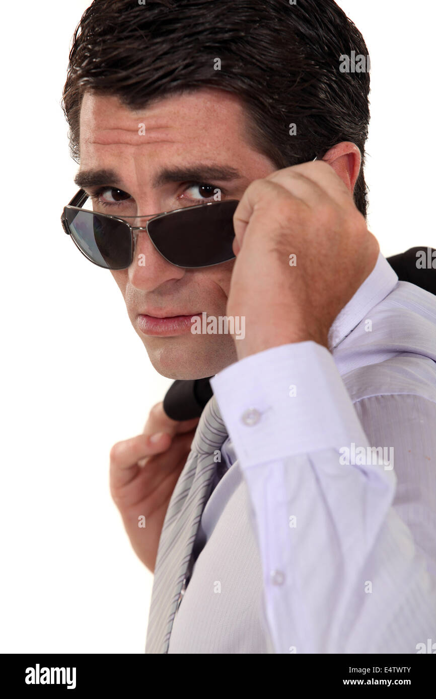 Imprenditore di sbirciare da dietro i suoi occhiali da sole Foto Stock