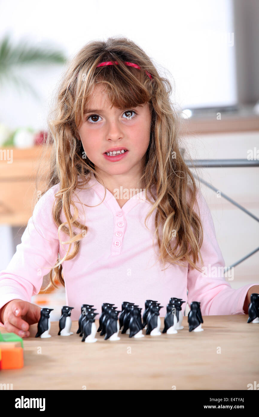 Bambina gioca con il pinguino figurine Foto Stock