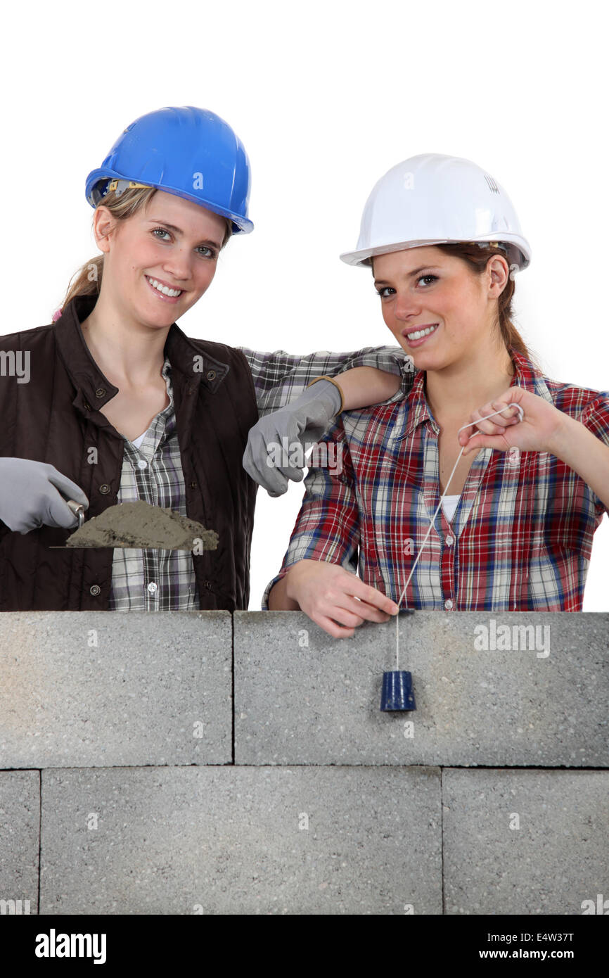 Due artigiane costruendo un muro Foto Stock