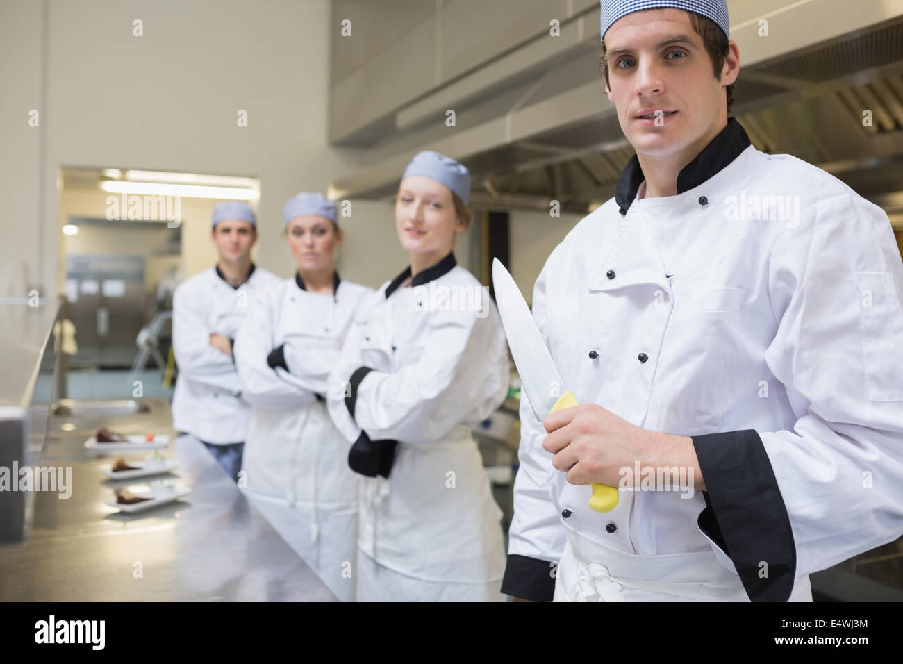 Il team di chef con uno in possesso di un coltello Foto Stock