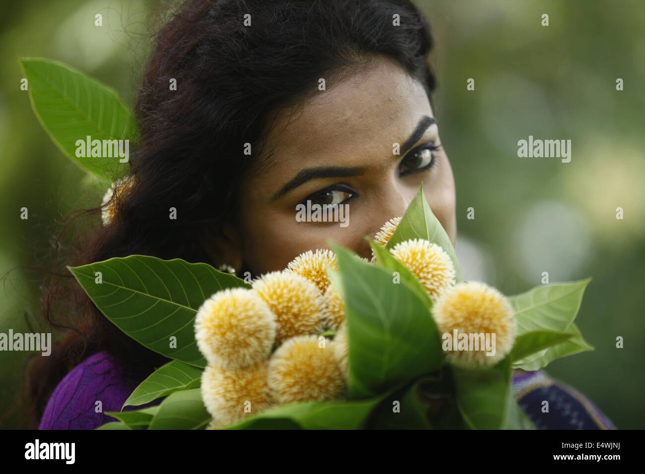 Ragazza con fiori kadam in Bangladesh Foto Stock