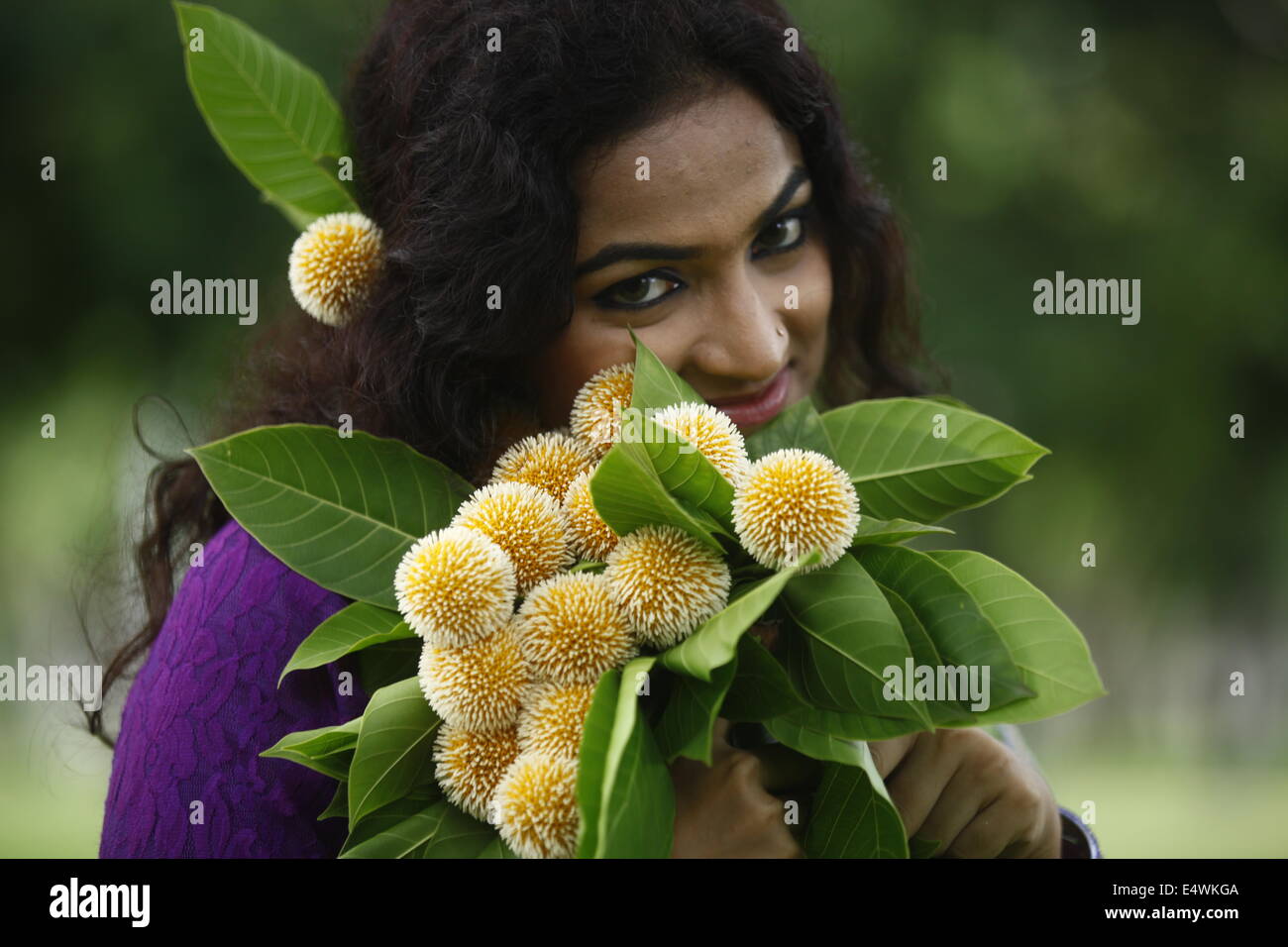 Ragazza con fiori kadam in Bangladesh Foto Stock