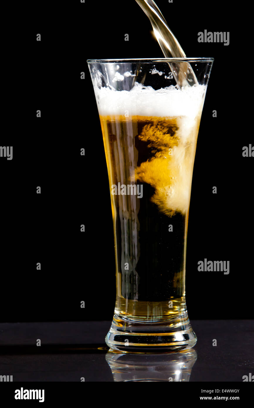 Essendo di vetro riempito con la birra Foto Stock