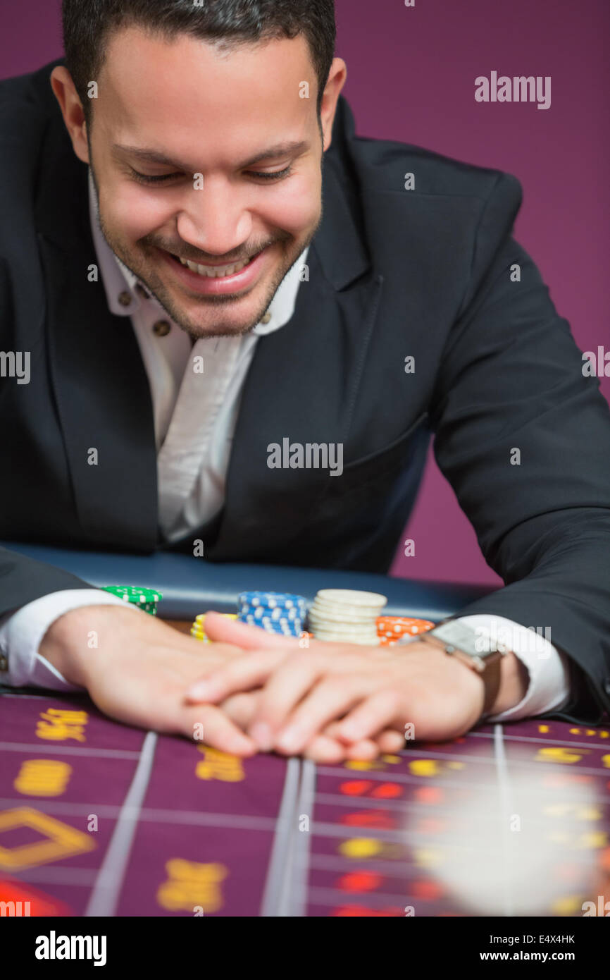 L'uomo felicemente grabbing chips Foto Stock
