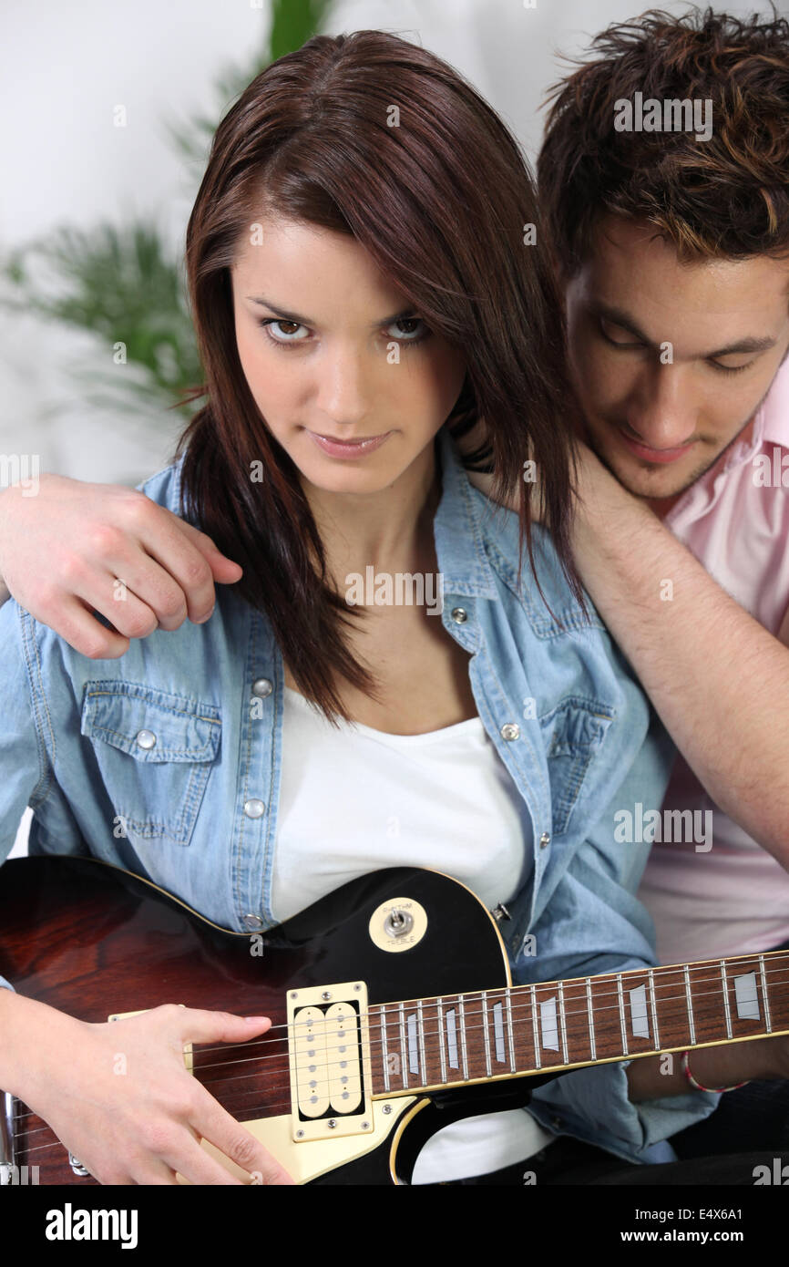 Giovane sat con chitarra elettrica Foto Stock