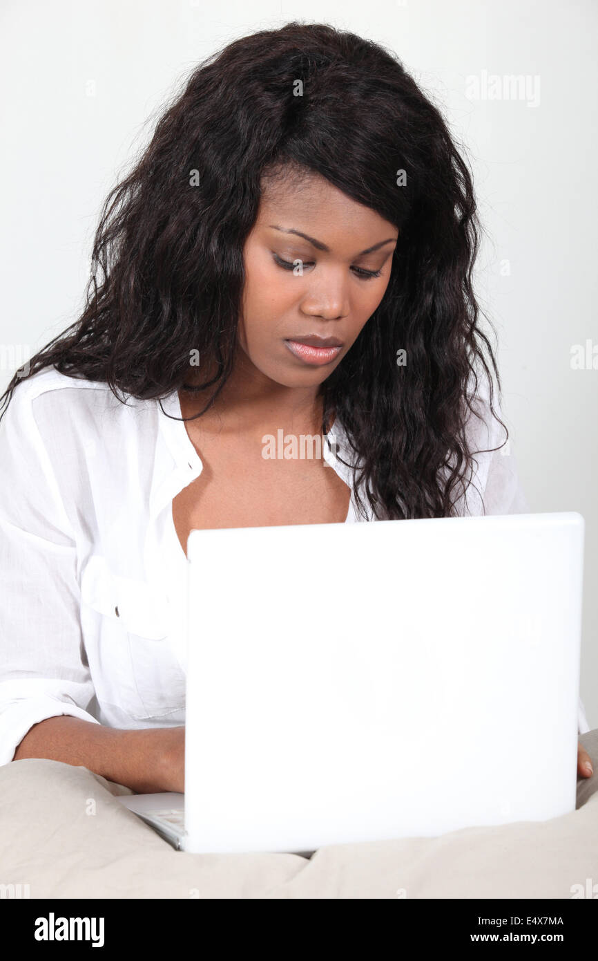 Nero donna utilizzando il computer portatile Foto Stock