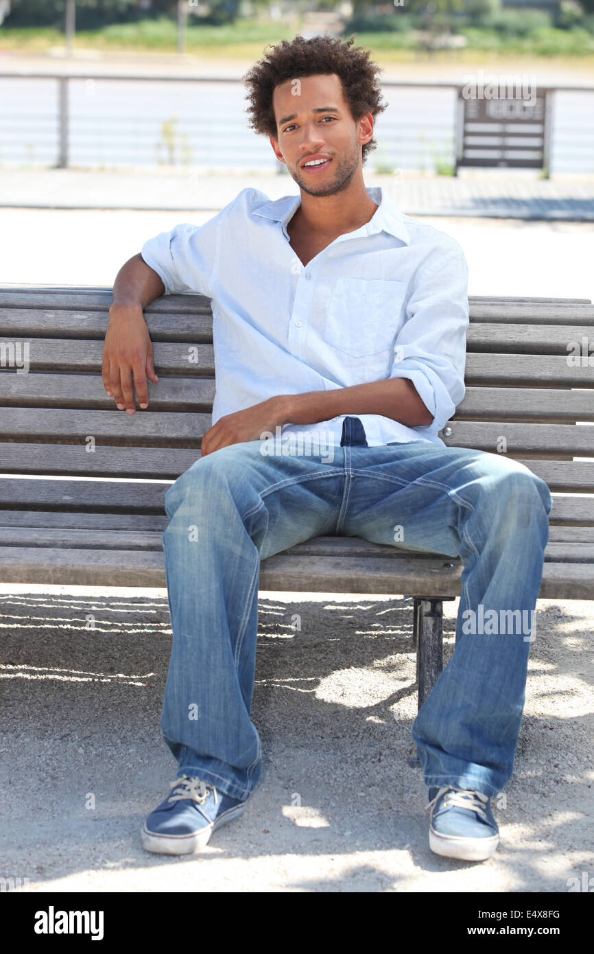 Giovane uomo seduto su un banco di lavoro Foto Stock