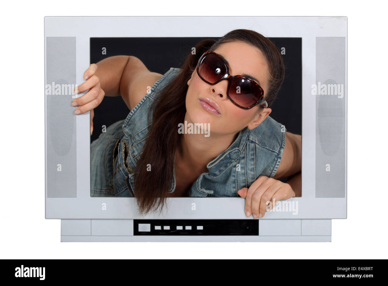 Donna uscente da uno schermo televisivo Foto Stock