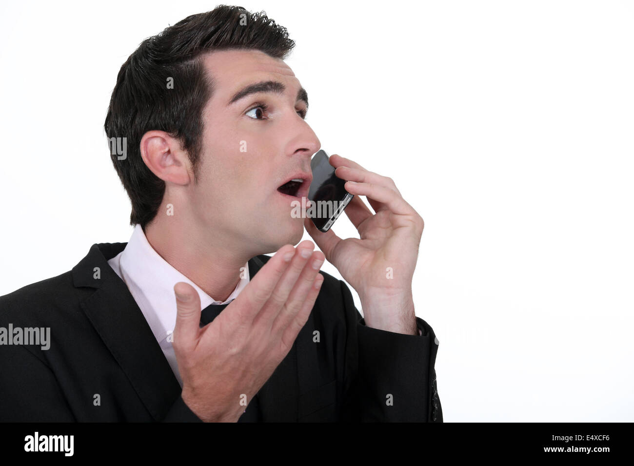 Scioccato imprenditore con un telefono mobile Foto Stock