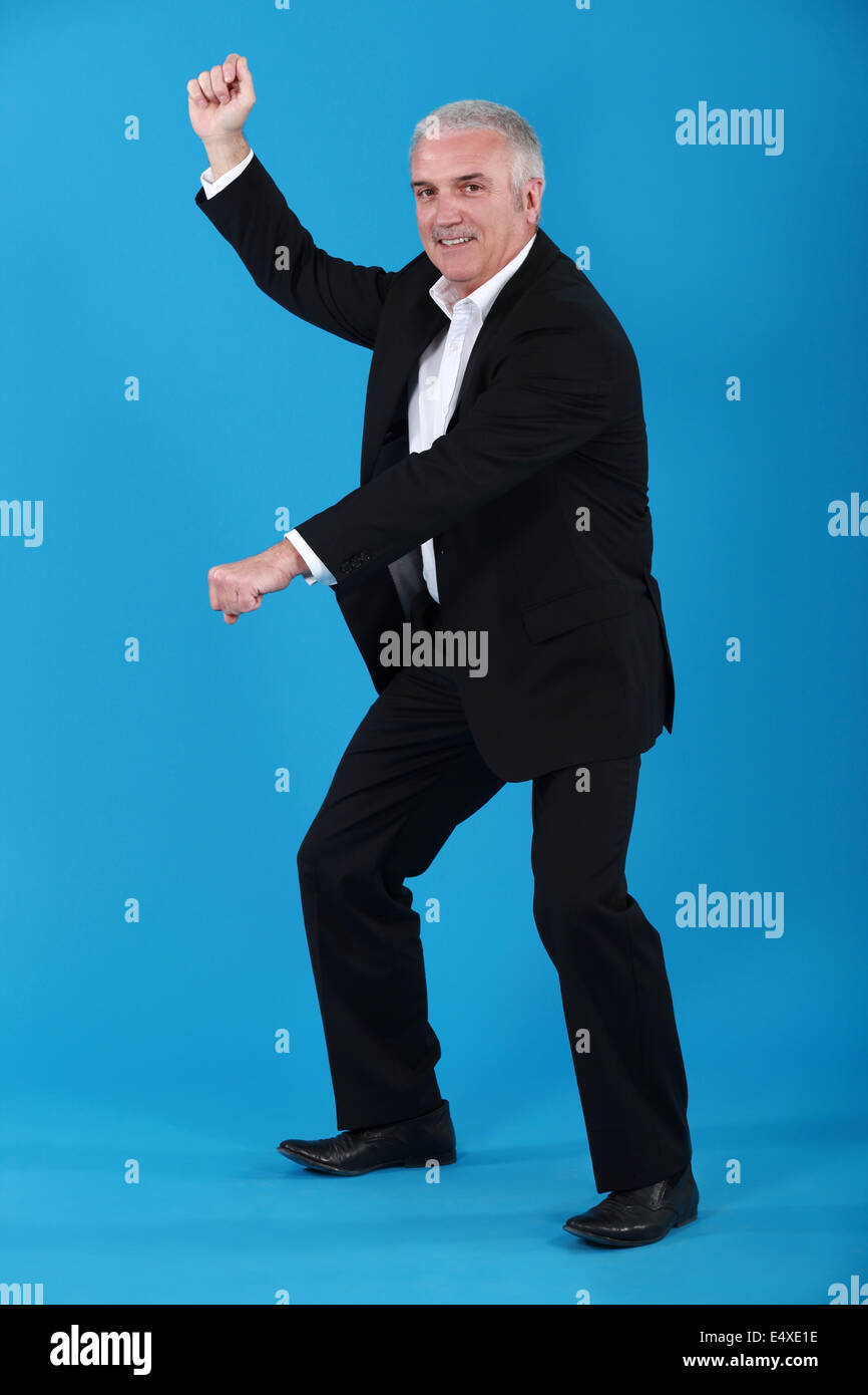 Imprenditore Senior fingendo di giri a cavallo Foto Stock