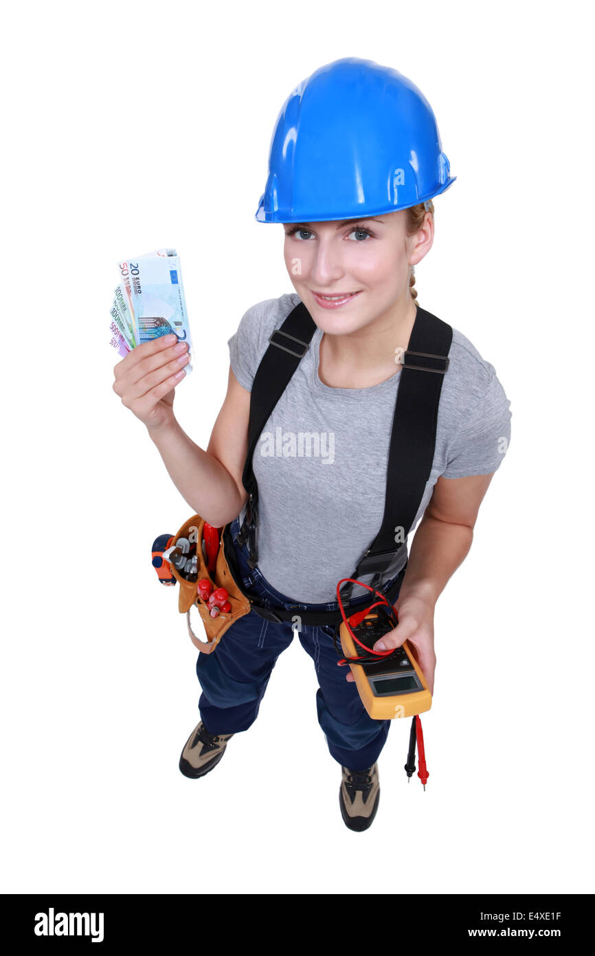 Elettricista femmina tenendo il cuneo di contanti Foto Stock